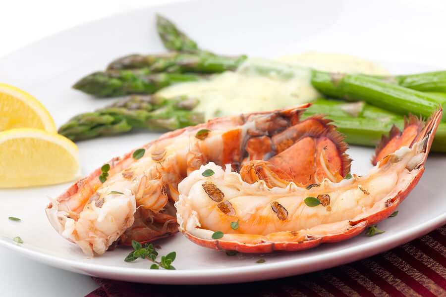 Closeup of delicious grilled lobster tails served with asparagus and bearnaise sauce